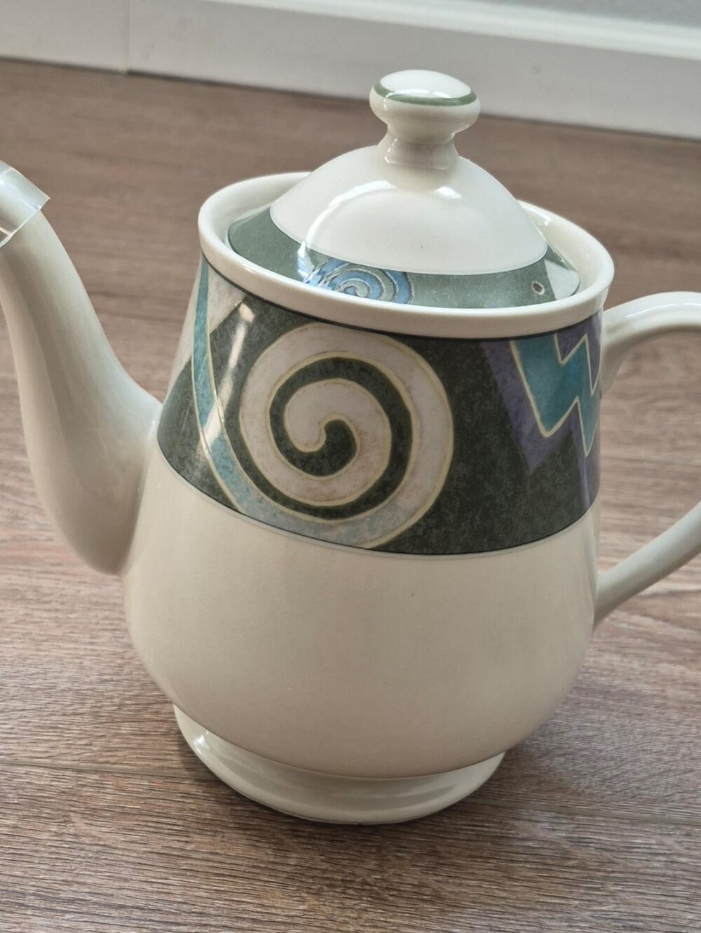White Ceramic Teapot with Green and Blue Decorative Spiral Band